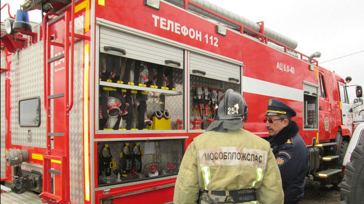 Спасатели и пожарные у пожарной машины